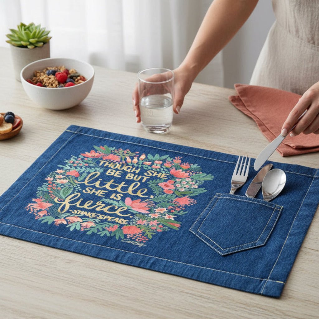 Denim placemat with floral design and text on a table setting with Shakespears text "Though She Be But Little, She is Fierce" printed by DenimINK. Little-and-fierce-by-CatCoq-table-placemat-lifestyle-shot