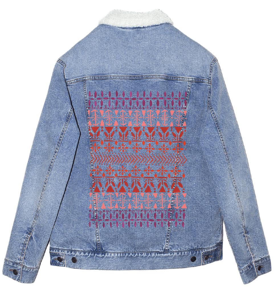 sherpa lined stonewash denim jacket with a geometric pattern on the back, a vertically aligned Scandinavian folk pattern "Norwegian Pattern" by CatCoq made of repeating geometric rows including tulip shapes, arrows, diamonds, snowflakes & stylized trees. the hand-painted elements fade from deep violet at the top to coral & rust red toward the center, then shift to pink & purple again. printed by DenimINK
