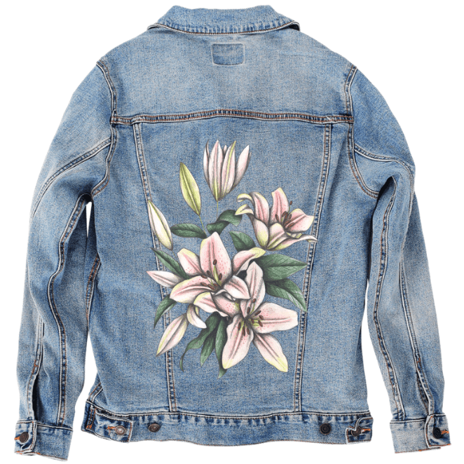 back view of a stonewashed denim jacket featuring a centered print of pale pink lilies with lime-tinged petals, curved white stamens & dense green foliage. the high contrast between the soft botanical illustration and the dark jacket creates a bold, striking visual. the artwork “Pink Lilies” by Cecilia Battaini is digitally printed on the jacket’s back panel by DenimINK.