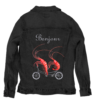 back view of a black denim jacket featuring the artwork “Shrimp Riding a Bicycle” by Amelia Legault, showing two bright red shrimp pedaling a small bicycle beneath the word “Bonjour.” the artwork is digitally printed on the jacket’s back panel by DenimINK