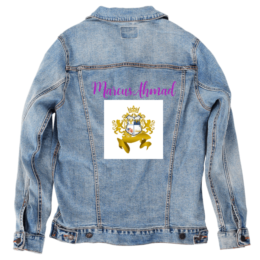 Customer designed custom denim jacket (2XL stonewash) featuring elegant purple cursive text reading “Marcus Ahmad” across the upper back. Beneath it sits a detailed gold crest emblem on a white square background. The crest includes curling ornamental flourishes, a central shield depicting scenic imagery, a crown at the top, and a flowing ribbon at the base in metallic gold tones. The polished, regal design contrasts with the rugged blue stonewash denim, creating a refined statement piece printed on denim ja