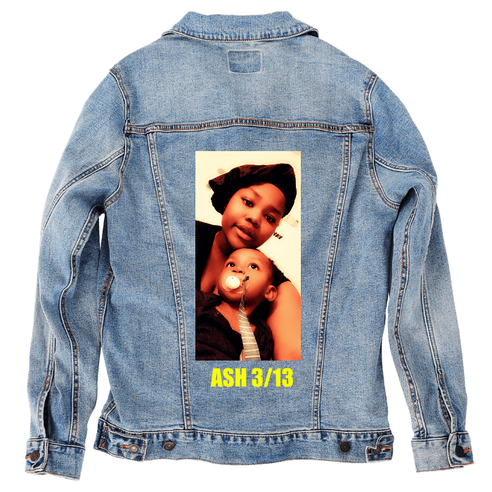 Customer designed custom denim jacket (L stonewash) featuring a bold black rectangular graphic printed on the back, displaying a large white stylized symbol with curved lines forming a mirrored abstract shape. Below the symbol, white uppercase text reads “EVERYONE LIVES ON.” The clean modern design and strong contrast between black, white, and the soft faded blue denim create a striking, minimalist statement piece, printed on denim jacket by DenimINK.