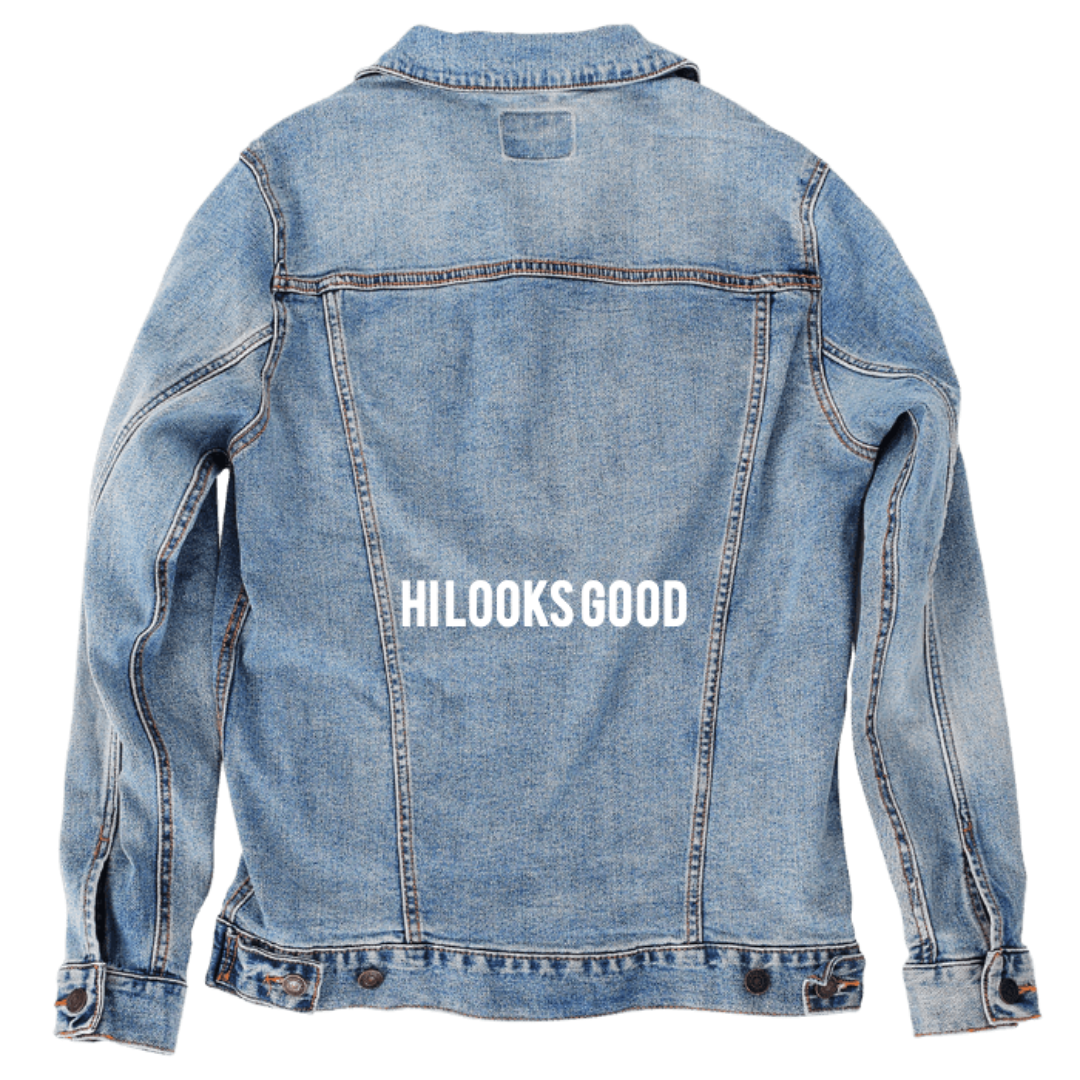 Customer designed custom denim jacket (S stonewash) featuring bold white uppercase lettering centered across the back that reads “HILOOKSGOOD.” The clean, block-style typography stands out sharply against the soft, faded blue denim, creating a simple yet confident personalized design that delivers strong visual contrast and a modern streetwear aesthetic, printed on denim jacket by DenimINK.