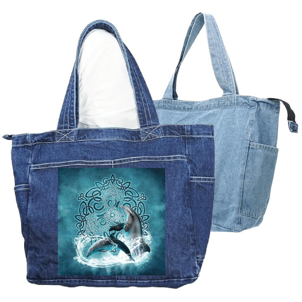 front view of a classic blue denim tote bag and back view of a stonewashed denim tote bag featuring the artwork “celtic dolphin” by brigid ashwood, printed large and centered on the front panel. the artwork depicts two realistic dolphins emerging through splashing water over a glowing teal and turquoise celtic knotwork circle on an aqua-toned background. the zippered tote bag includes reinforced handles and exterior pockets. digitally printed by DenimINK.
