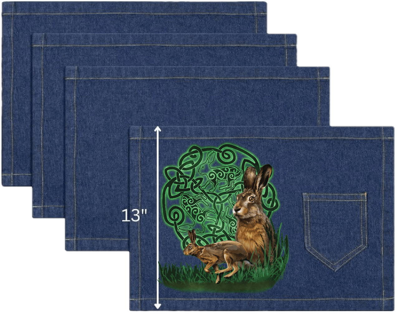 top view of four classic blue denim table placemats featuring the artwork “celtic hare” by brigid ashwood, printed centered on the surface. the artwork shows two brown hares, one standing alert and one crouched, positioned in green grass in front of a glowing green celtic knotwork circle with animal motifs woven into the design. each placemat includes a stitched pocket, one-inch stitched seams, and visible white measurement text and arrow indicating a height of 13 inches. digitally printed by DenimINK.