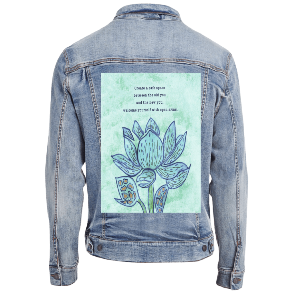 back of stonewashed denim jacket featuring a blue lotus flower on a textured light-green background, paired with the quote “Create a safe space between the old you and the new you; welcome yourself with open arms.” the artwork is titled “Always Welcome Yourself” and created by Canvas &amp; Quotations (Monika Chugh and Alka Chopra) and printed by DenimINK
