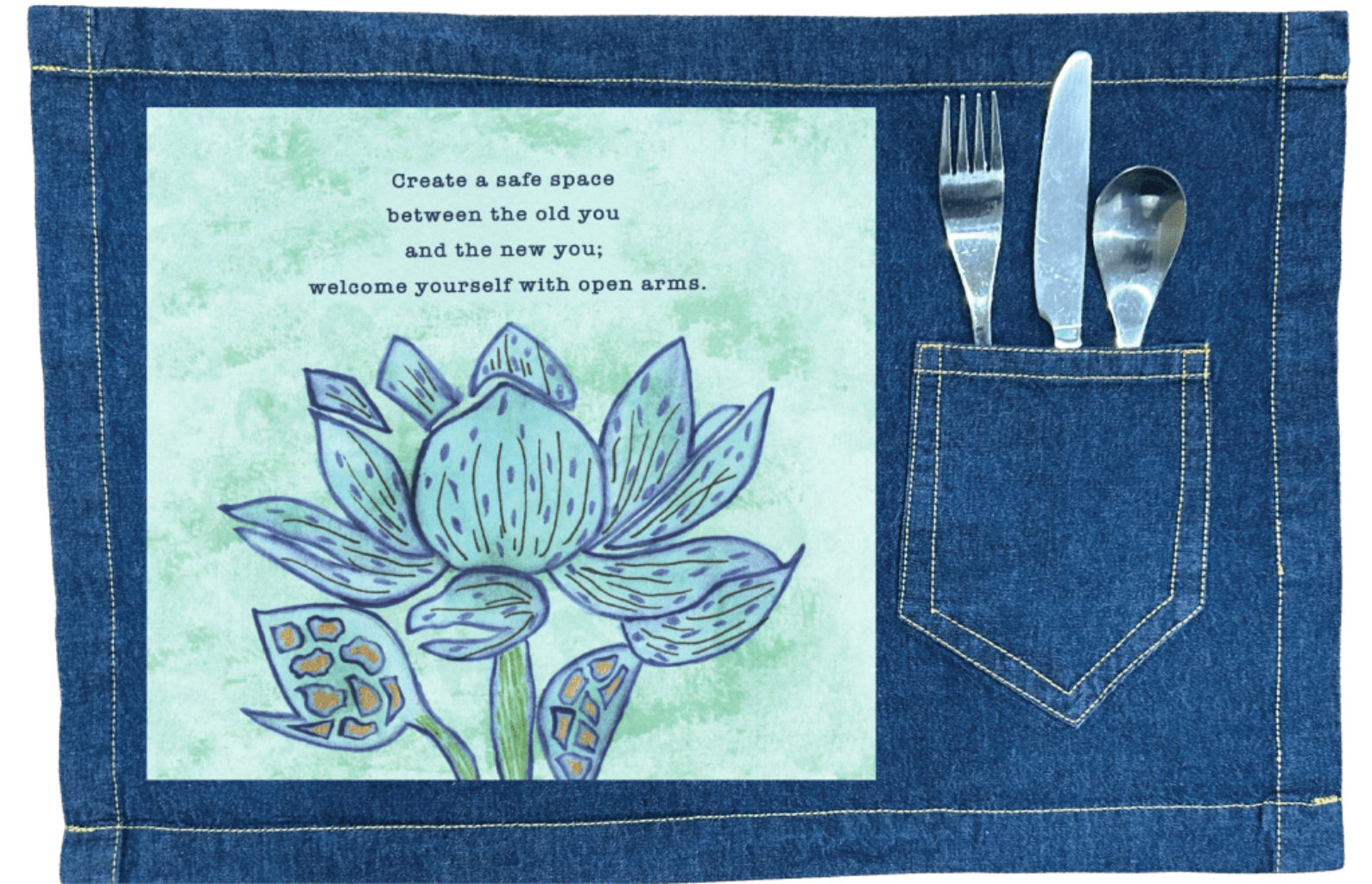 denim table placemat with utensils mockup featuring a blue lotus flower on a textured light-green background, paired with the quote “Create a safe space between the old you and the new you; welcome yourself with open arms.” the artwork is titled “Always Welcome Yourself” and created by Canvas &amp; Quotations (Monika Chugh and Alka Chopra) and printed by DenimINK