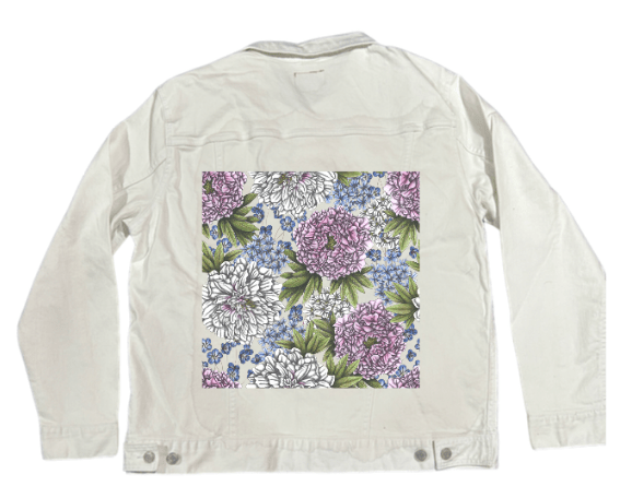 back view of a white denim jacket featuring a delicate pastel composition of lilac &amp; ivory peonies surrounded by tiny blue wildflowers &amp; soft green leaves. the crisp fabric brings out the airy, layered pencil detailing. the artwork “Peonies” by Cecilia Battaini is digitally printed on the jacket’s back panel by DenimINK.