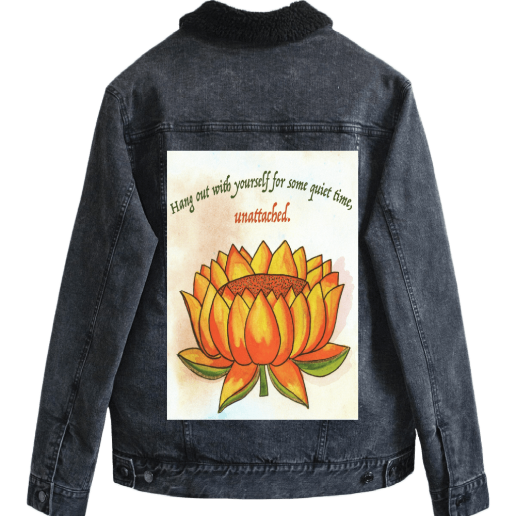 mockup on a sherpa-lined black denim jacket eaturing a warm-toned orange lotus flower on a textured background, paired with the quote “Hang out with yourself for some quiet time, unattached.” rendered in green and red script. this artwork is titled “Be Unattached” and created by Canvas &amp; Quotations (Monika Chugh and Alka Chopra) printed by DenimINK