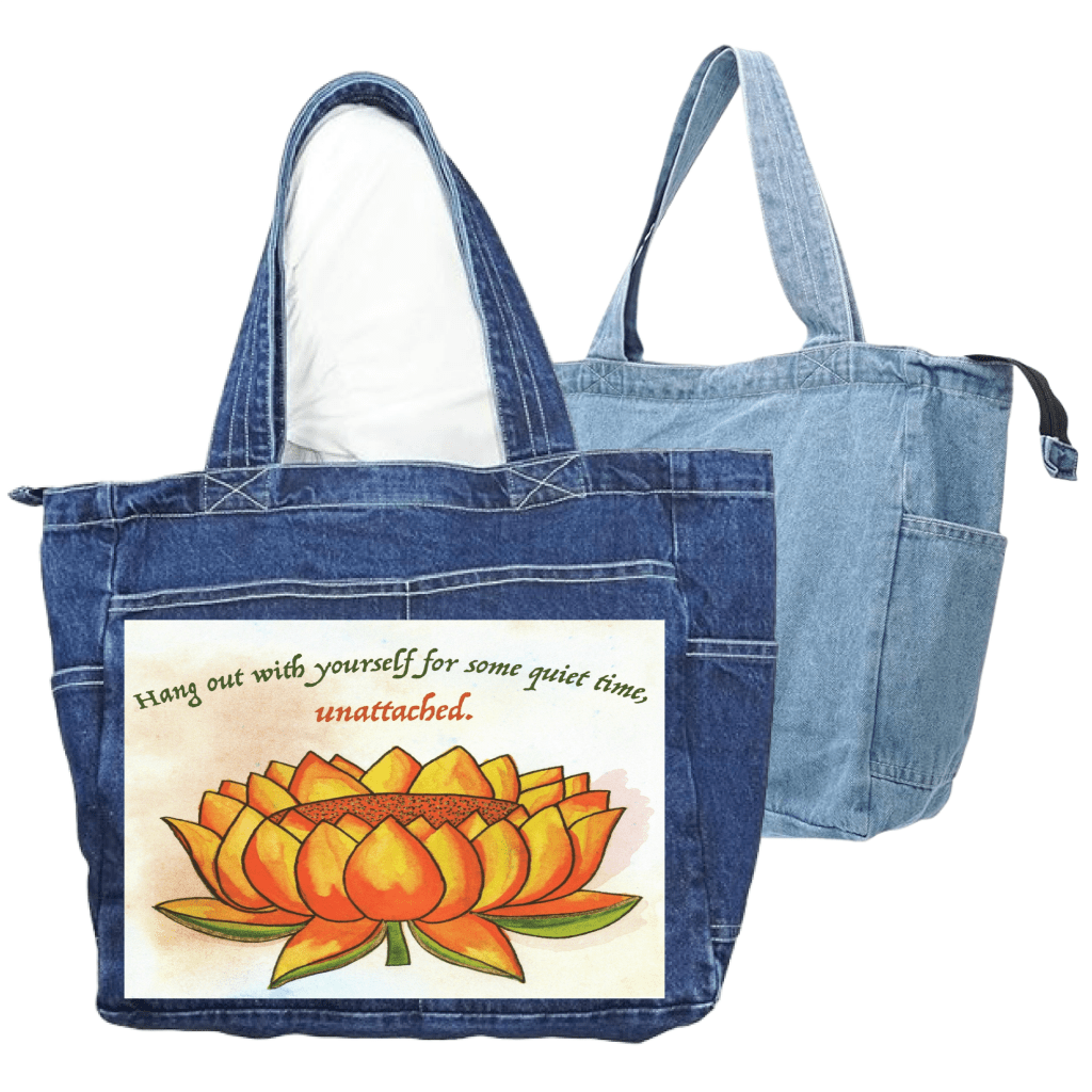 denim zippered tote bags with end pockets and side pockets featuring a warm-toned orange lotus flower on a textured background, paired with the quote “Hang out with yourself for some quiet time, unattached.” rendered in green and red script. this artwork is titled “Be Unattached” and created by Canvas &amp; Quotations (Monika Chugh and Alka Chopra) printed by DenimINK