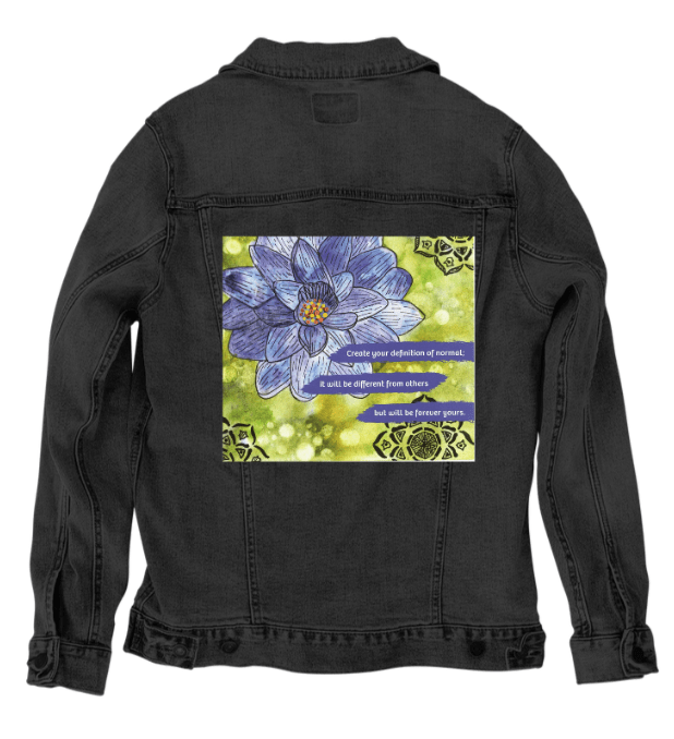 back view of a black denim jacket featuring the artwork “Be Your Normal Self” by Canvas &amp; Quotations, displaying a blue lotus flower and inspirational quote across a green textured background with decorative mandala patterns. the artwork is digitally printed on the jacket’s back panel by DenimINK