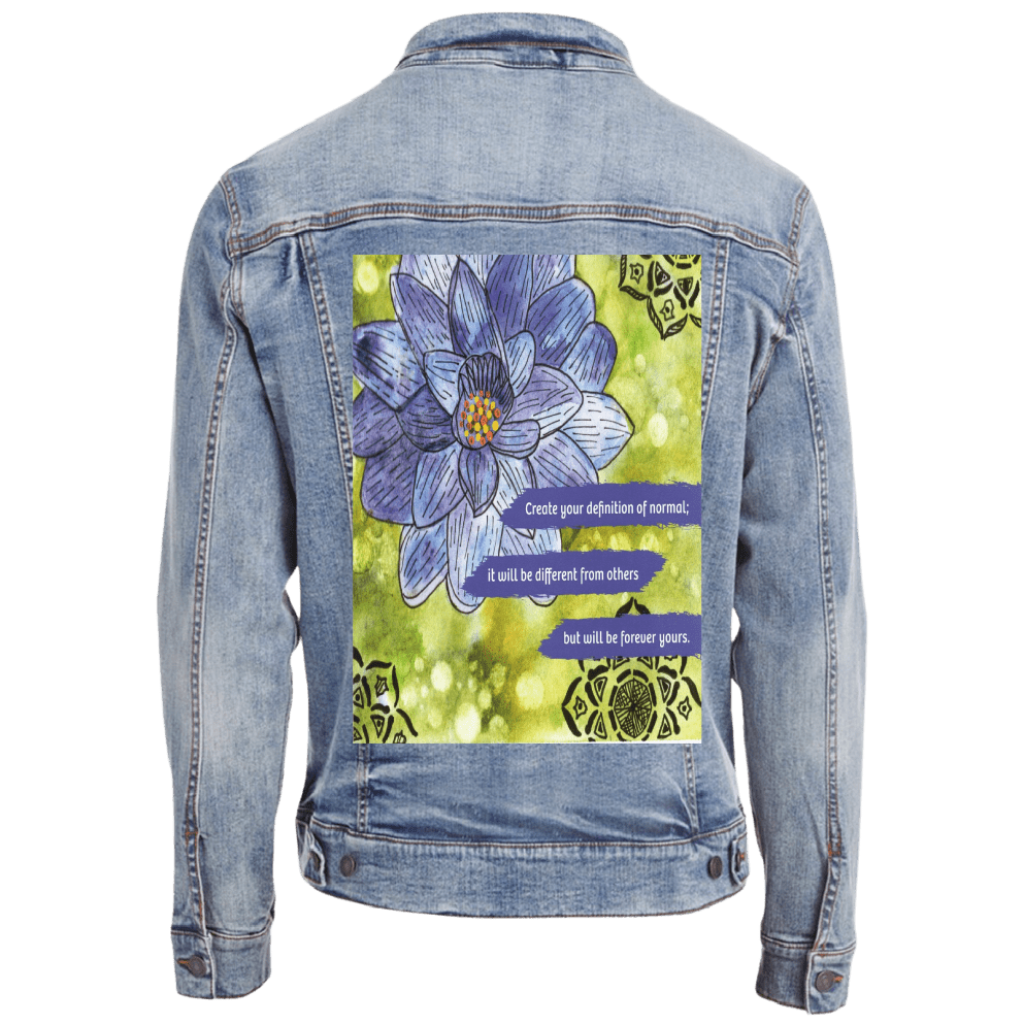 stonewashed denim jacket mockup featuring a blue and purple lotus flower on a textured green background, paired with the quote “Create your definition of normal; it will be different from others but will be forever yours.” decorative black mandala-style motifs appear in the corners. this artwork is titled “Be Your Normal Self” and created by Canvas &amp; Quotations (Monika Chugh and Alka Chopra), printed by DenimINK