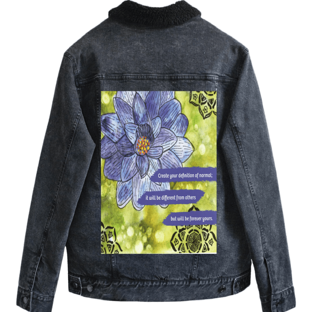 sherpa-lined black denim jacket mockup featuring a blue and purple lotus flower on a textured green background, paired with the quote “Create your definition of normal; it will be different from others but will be forever yours.” decorative black mandala-style motifs appear in the corners. this artwork is titled “Be Your Normal Self” and created by Canvas &amp; Quotations (Monika Chugh and Alka Chopra), printed by DenimINK