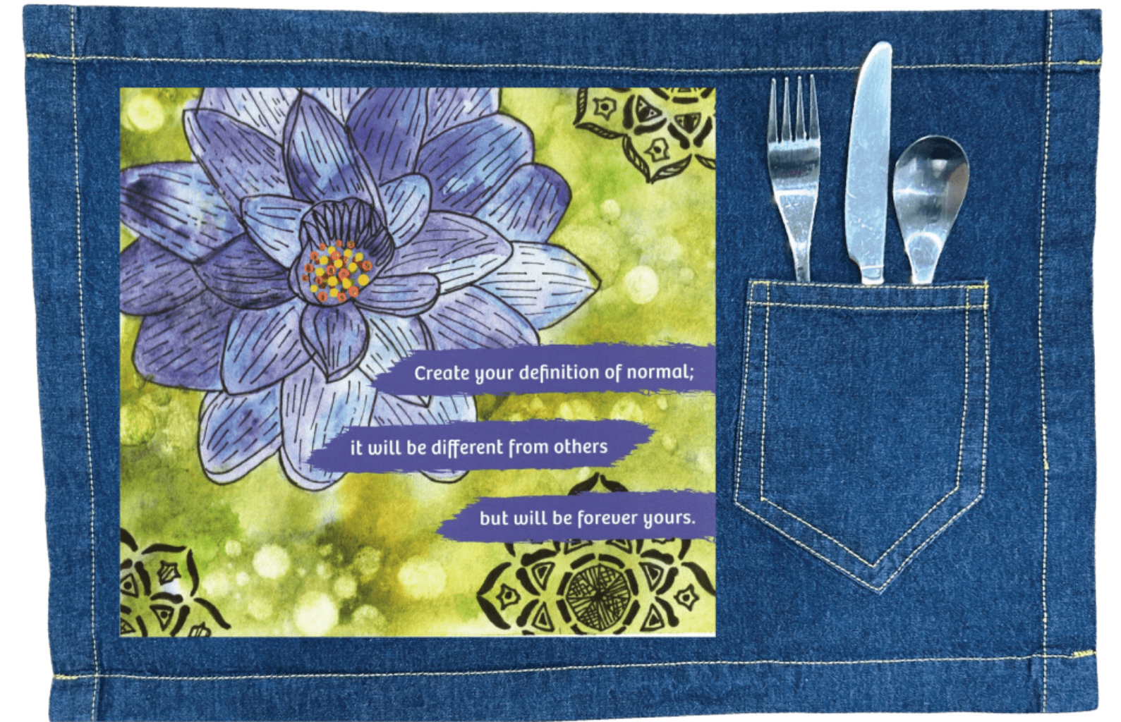 blue denim table placemat with stitching around the edge, and a pocket for silverware featuring a blue and purple lotus flower on a textured green background, paired with the quote “Create your definition of normal; it will be different from others but will be forever yours.” decorative black mandala-style motifs appear in the corners. this artwork is titled “Be Your Normal Self” and created by Canvas &amp; Quotations (Monika Chugh and Alka Chopra), printed by DenimINK