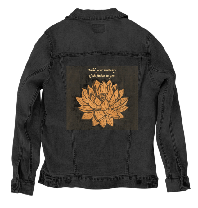 back view of a black denim jacket showcasing the artwork “Be Your Own Sanctuary” by Canvas &amp; Quotations, featuring a golden lotus flower beneath an inspirational quote on a deep textured background. the artwork is digitally printed on the jacket’s back panel by DenimINK