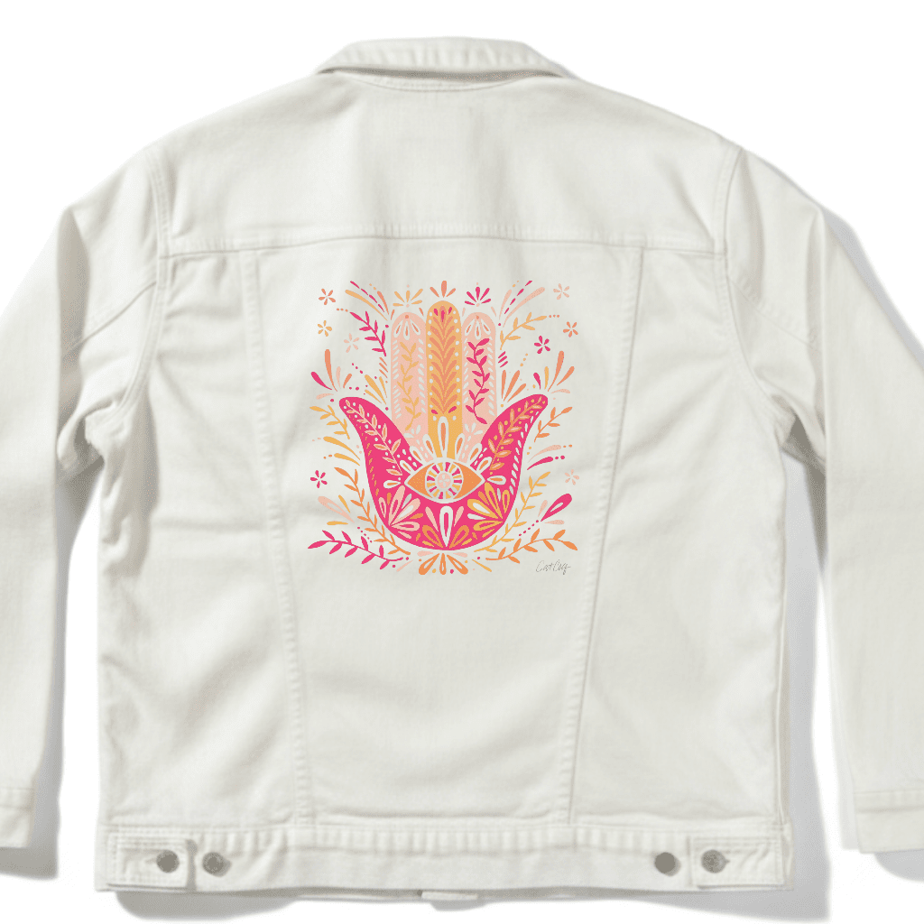 White denim jacket with a colorful hamsa hand design on the back. hamsa-hand-catcoq-denim_jacket_white-mockup