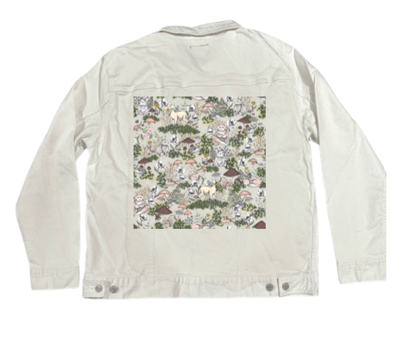 back view of a white denim jacket featuring the artwork “Into the Woods” by Cecilia Battaini, a hand-drawn woodland pattern filled with gentle forest animals—deer, owls, squirrels, rabbits &amp; hedgehogs—nestled among pale mushrooms, flowering vines, moss &amp; scattered leaves. the soft watercolor lines &amp; creamy palette stand out crisply on the white denim. the design is digitally printed on the jacket’s back panel by DenimINK.