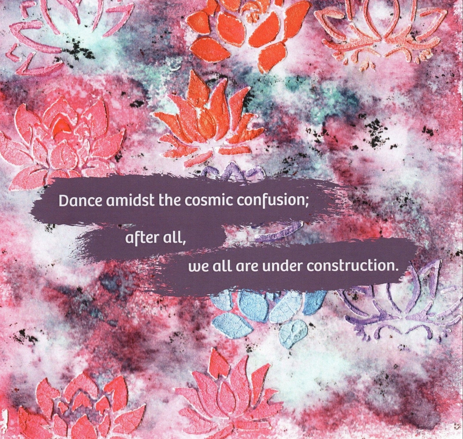 illustration featuring layered lotus flower motifs in orange, pink, and lavender over a textured cosmic-style background of marbled purples, reds, blacks, and blues. across the center, a painted purple brushstroke displays the quote: “Dance amidst the cosmic confusion; after all, we all are under construction.” this artwork is titled “Just Dance” and created by Canvas & Quotations (Monika Chugh and Alka Chopra)