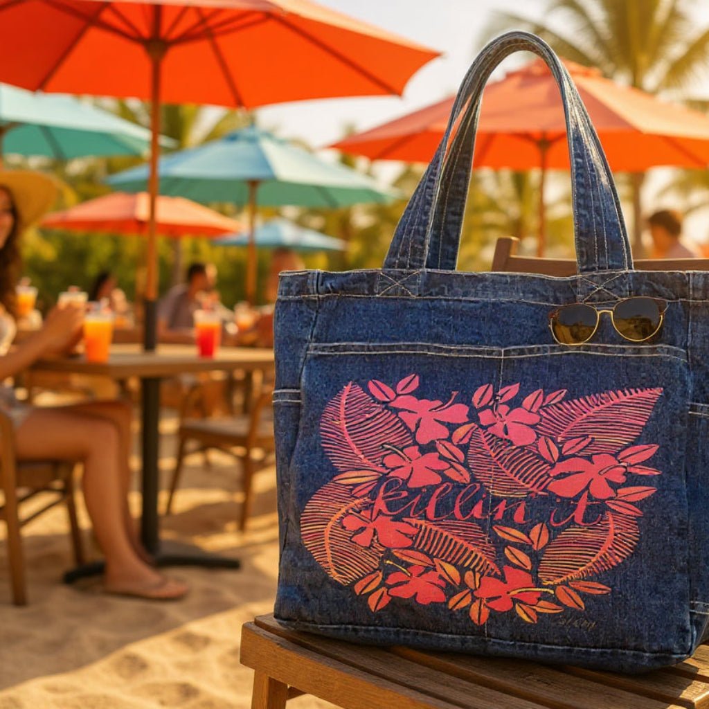 Blue denim tote bag with pink floral design on a chair outdoors.  killin-it-by-CatCoq-denim-tote-bag-lifestyle-shot