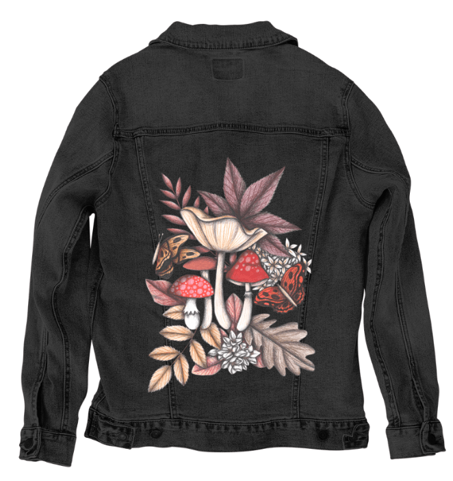 back view of a black denim jacket featuring a moody woodland arrangement of mushrooms, florals &amp; butterflies. rich reds, ochres &amp; tans contrast with deep browns &amp; soft grays in a storybook-style forest design. the artwork “Mushroom Magic 3” by Cecilia Battaini is digitally printed on the jacket’s back panel by DenimINK.