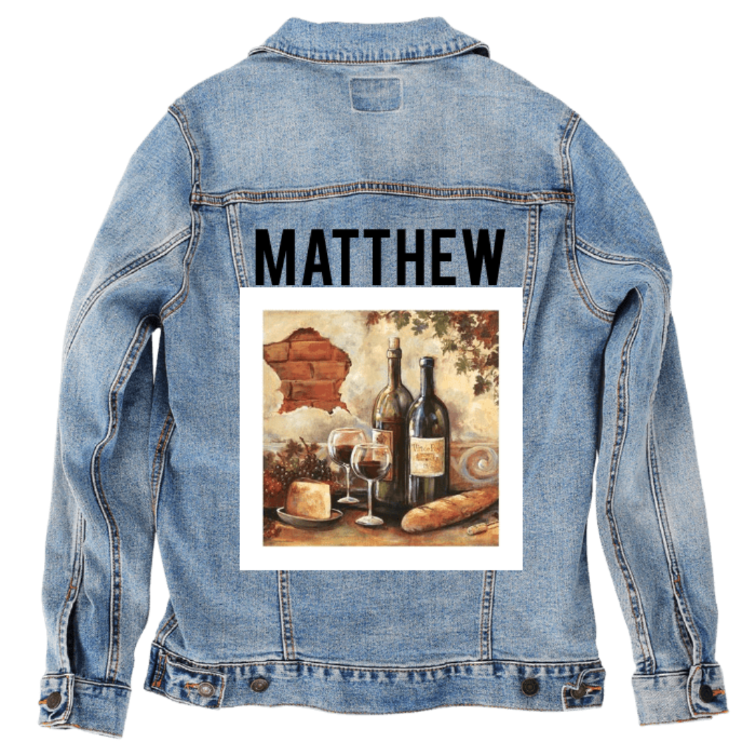 Customer designed custom denim jacket (2XL stonewash) featuring bold black lettering across the upper back that reads “MATTHEW,” paired with a warm-toned still-life painting printed below. The artwork shows two wine bottles, filled glasses, a loaf of bread, cheese, and rustic wall textures, creating a cozy, European-inspired scene. The rich colors and classic composition contrast beautifully with the soft, faded blue denim, printed on denim jacket by DenimINK.