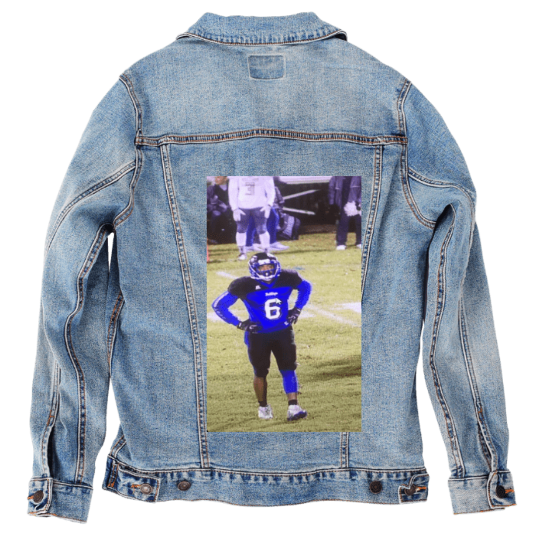ADA-safe, no identification, ends with DenimINK)

Customer designed custom denim jacket (M stonewash) featuring a full-color photograph of a football player printed on the back, showing an athlete in a blue jersey with the number 6, standing on a lit grassy field with hands on hips. The scene captures the energy of a nighttime game, with blurred figures and stadium lighting behind him, creating a bold, dynamic contrast against the faded blue denim, printed on denim jacket by DenimINK.