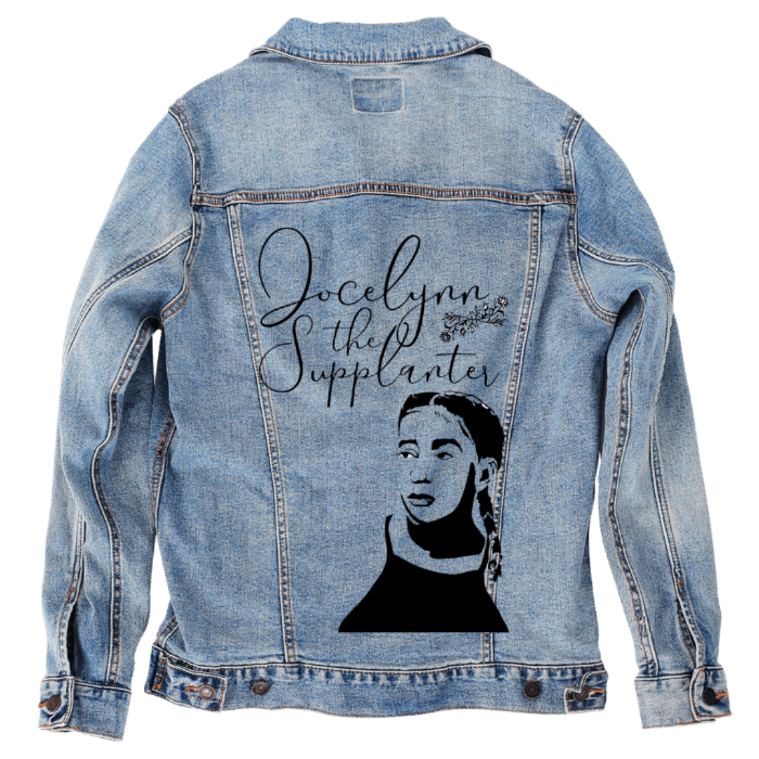 Customer designed custom denim jacket (S stonewash) featuring elegant black script lettering that reads “Jocelynn the Supplanter,” adorned with a small floral accent, printed across the upper back. Below the text is a bold black silhouette-style portrait of a woman with braided hair, rendered in a clean graphic cutout style. The combination of refined typography and minimalist portrait art creates a striking personalized design on the faded blue denim, printed on denim jacket by DenimINK.